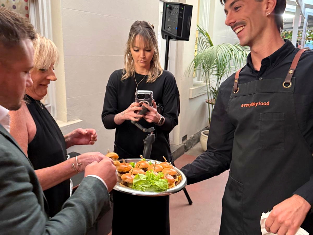 An everydayfood team member serving guests at an event